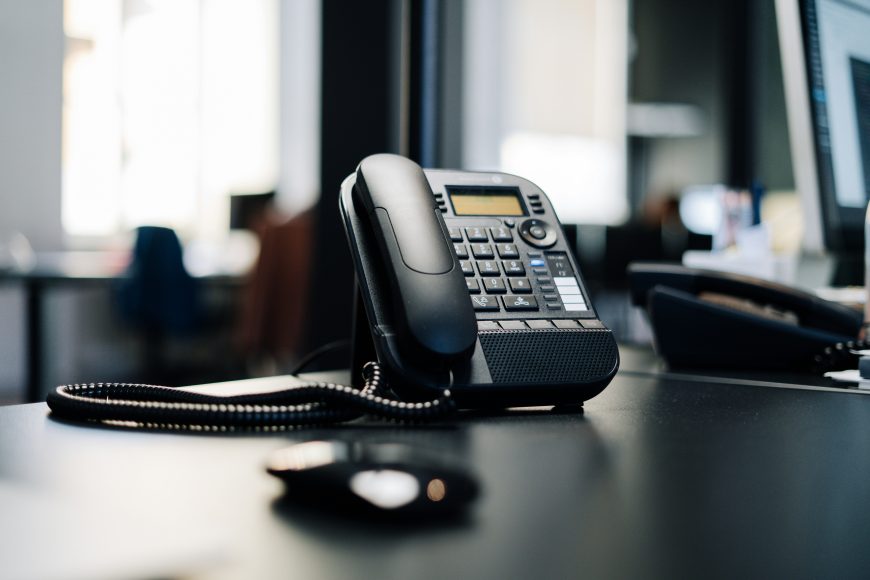 Office telephone on dark desk